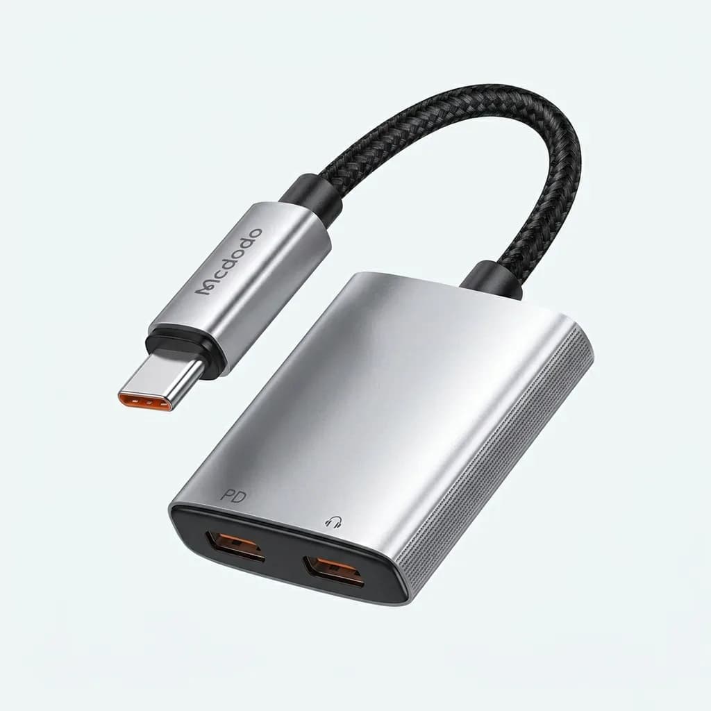 Silver Mcdodo 2-in-1 USB-C audio and charging adapter with two USB-C female ports and a short black braided cable, displayed on a white background.